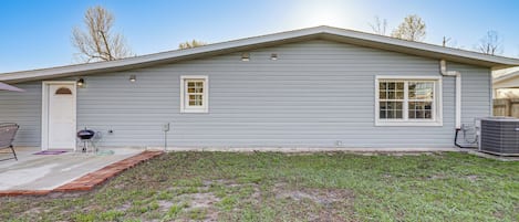 A single-story house with a front porch, a small attached garage, and a clear sky.