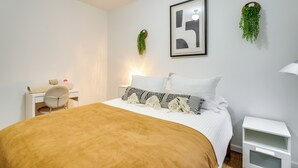 A bedroom with a bed, a desk, a chair, and a nightstand. - 1 Mi to Comerica Park: Convenient Couple's Retreat (Detroit)