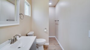 A bathroom with a sink, toilet, and shower. - 2 Mi to Nat'l Park: Riverside Smoky Mtn Cabin! (Townsend)