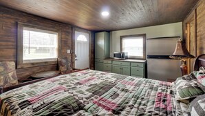 A bedroom with a wooden ceiling, a bed with a quilt, a desk with a lamp, and a window with blinds. - 2 Mi to Nat'l Park: Riverside Smoky Mtn Cabin! (Townsend)