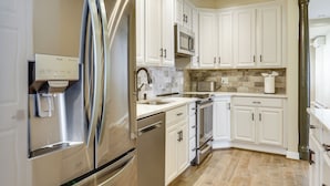 A modern kitchen with stainless steel appliances, white cabinetry, and a stone backsplash. - Extended Stay in Skylands! Pet-friendly Retreat (Glenwood)