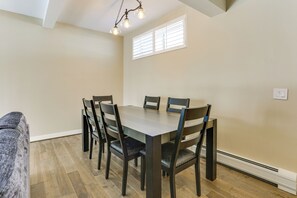 Comedor con una mesa rectangular, seis sillas y una lámpara colgante.