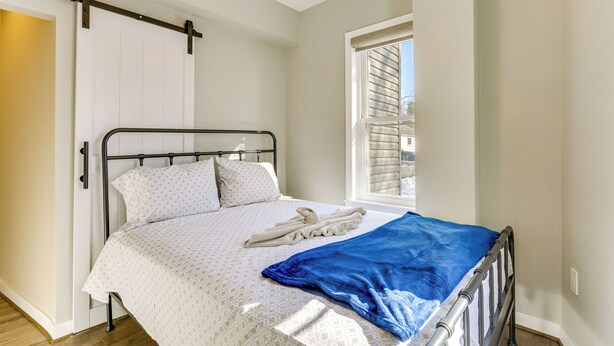 A bedroom with a bed, a window, a ceiling fan, and a door. - Extended Stay in Skylands! Pet-friendly Retreat (Glenwood)