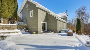 A two-story house with a stone foundation, a front door, and a covered porch. - Extended Stay in Skylands! Pet-friendly Retreat (Glenwood)