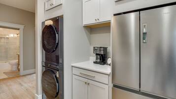 A modern kitchen with stainless steel appliances, a built-in oven, and a coffee maker.