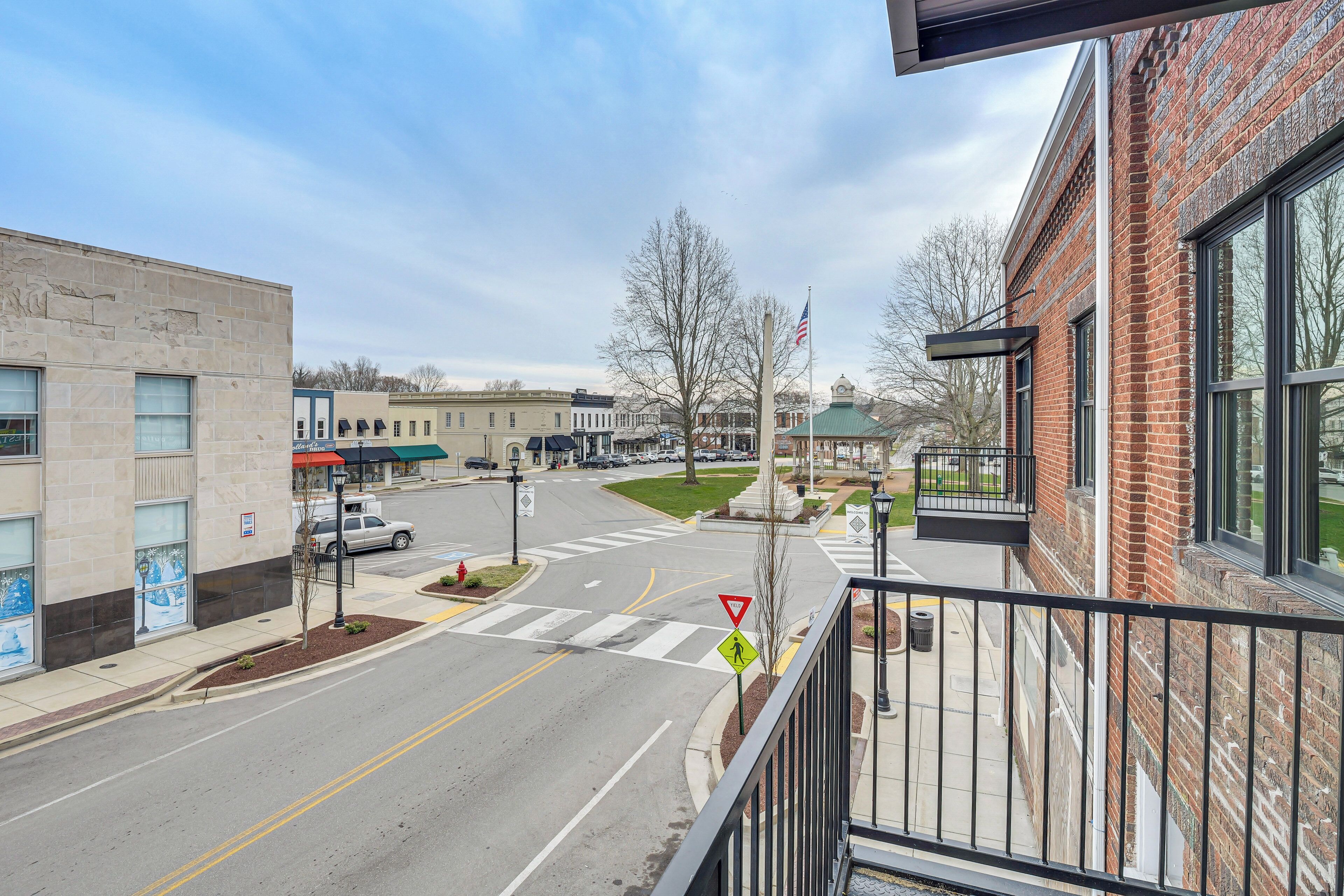 A street view with a building featuring large windows and a brick facade.
