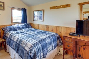 Un dormitorio con cama, cómoda de madera y televisor.