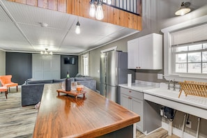 A modern kitchen with a wooden island, stainless steel appliances, and a window with blinds. - Shenandoah Valley Retreat: Hike, Fish & Explore! (Broadway)