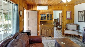Un interno in legno con un divano in pelle, un armadio in legno e una ventola a soffitto.