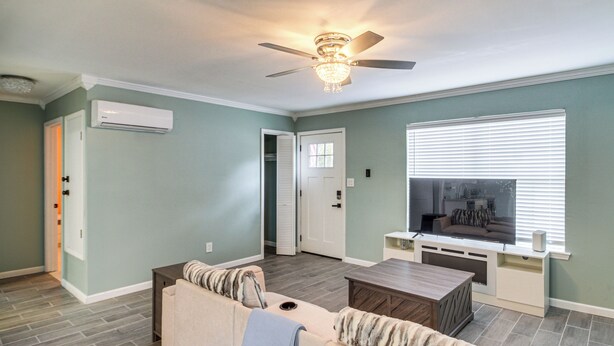 A living room with a ceiling fan, a TV, and a sofa. - Fun in the Sun w/ Family - Pensacola Duplex + Yard (Pensacola)