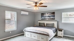 A bedroom with a bed, a ceiling fan, a nightstand, and a window. - Fun in the Sun w/ Family - Pensacola Duplex + Yard (Pensacola)