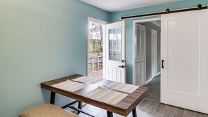 A room with a table, bench, and sliding door leading to a patio. - Fun in the Sun w/ Family - Pensacola Duplex + Yard (Pensacola)