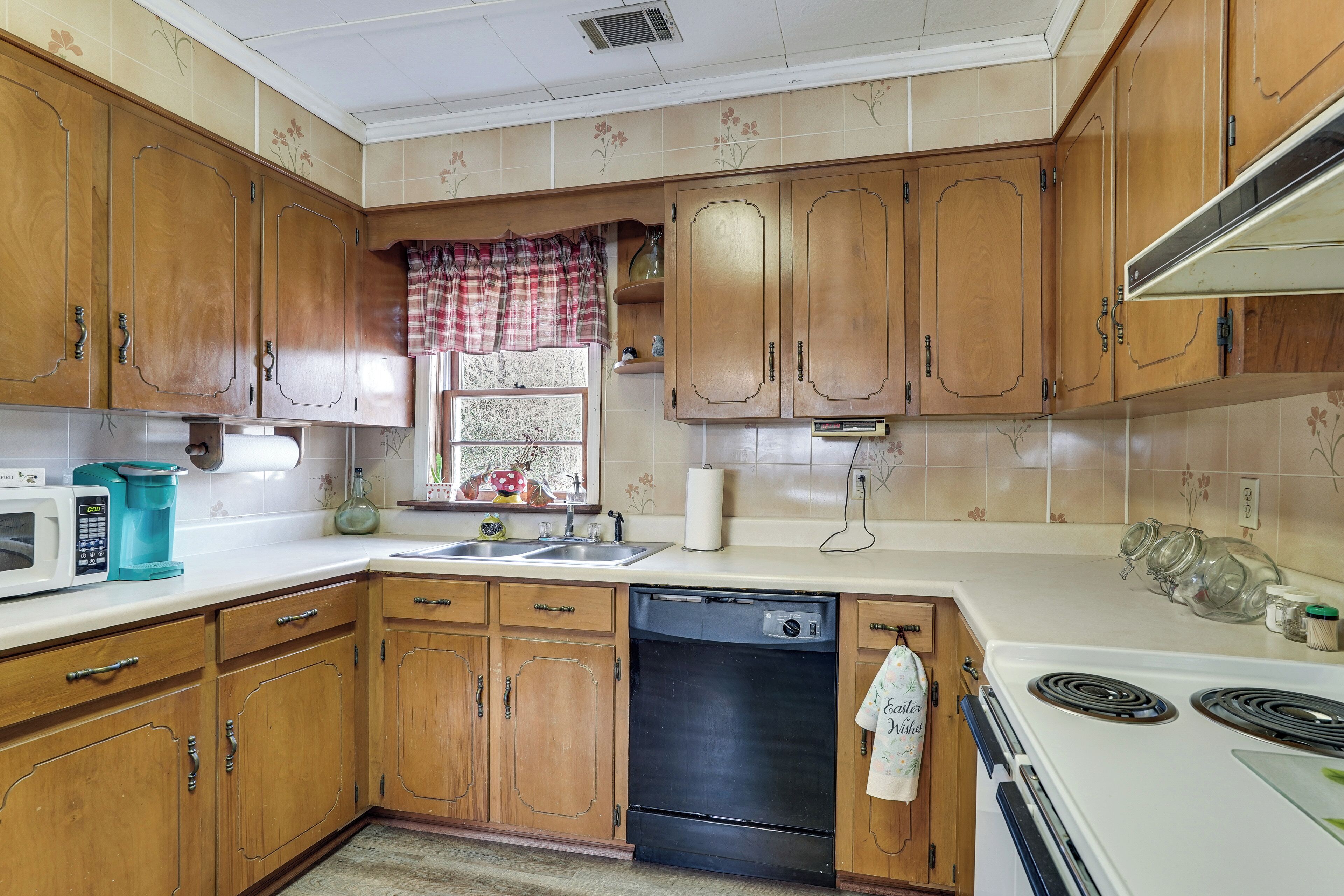 A kitchen with wooden cabinets, a microwave, a dishwasher, and a stove.