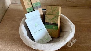 Una cesta tejida con varios artículos empaquetados sobre una superficie de madera.