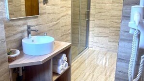 Un baño con lavabo, espejo, toallero y ducha.