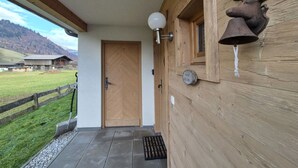 A wooden exterior with a door, a bell, and a deer head decoration. - 5_3 Chalet Noriker by Interhome (Niedernsill)