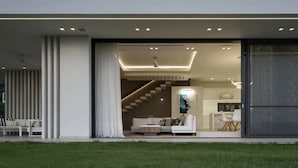 A modern house with a spacious living area, a staircase, and a dining area. - Μaraviglia Ethereon Villa by RentalsPro (Nikiti)