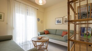 Ein Zimmer mit einer Couch, einem runden Tisch und einem Bett.