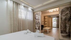 Ein Hotelzimmer mit einem Bett, einem kleinen Tisch, einem Stuhl, einem Kleiderschrank und einer Tür zu einem Flur.