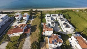 Ein Küstenwohngebiet mit modernen Gebäuden, einem Strand und freiem Blick auf das Meer.