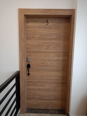 A wooden door with a number '5' and a keypad lock.