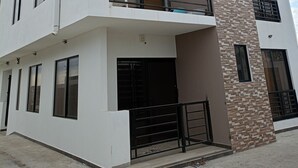 A multi-story building with balconies, large windows, and a modern architectural style. - Charming 2-bedroom apartment with AC in sunny Playas (Playas)