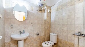 Un bagno con lavandino, WC e doccia.