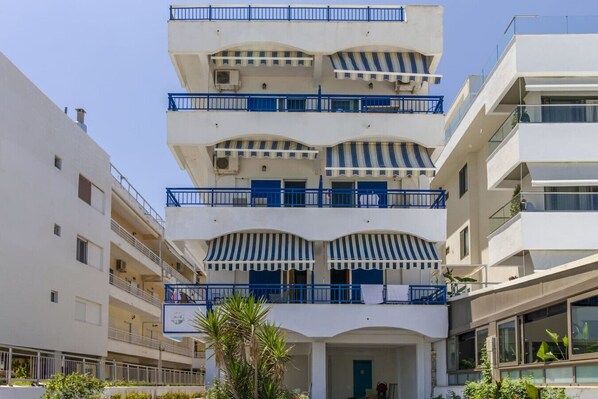 A multi-story building with balconies, air conditioning units, and a central atrium. - Poseidon Edge No6 by RentalsPro - Kallithea (Kallithea)