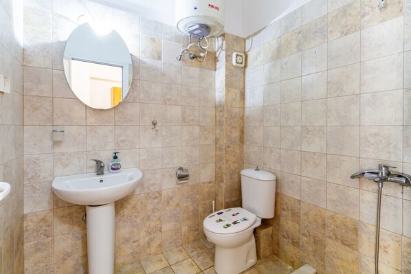 Un baño con lavamanos, inodoro y ducha.