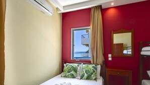 Ein Hotelzimmer mit Bett, einem Fenster mit Blick, einem Spiegel und einem Stockbett.