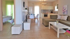 Un salon moderne comprenant un canapé, une table basse et un coin repas avec des chaises et une table.