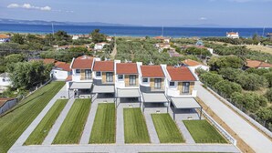 A residential area with modern houses, a clear view of the sea, and a well-maintained lawn. - Chryssis Village by Travel Pro Services - Nea Potidaia Halkidiki (Nea Potidaia)