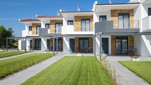 A modern residential building with multiple balconies, a covered patio area, and a well-maintained lawn. - Chryssis Village by Travel Pro Services - Nea Potidaia Halkidiki (Nea Potidaia)