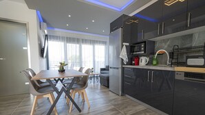 A modern kitchen with dark cabinets, a microwave, and a coffee maker. - Chryssis Village by Travel Pro Services - Nea Potidaia Halkidiki (Nea Potidaia)
