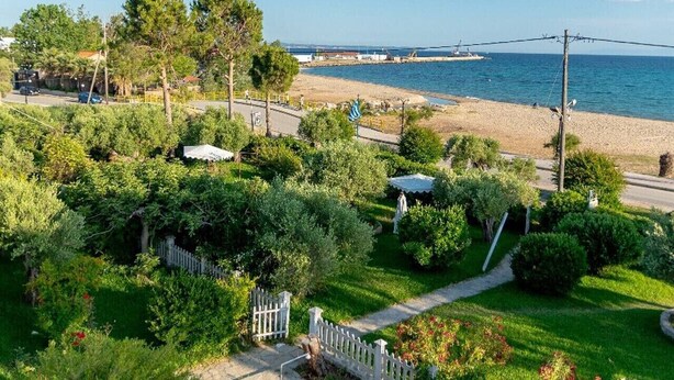 A coastal property with a paved pathway, a white fence, and a view of the sea. - Dimi Seafront Αpartment by Rentals Pro (Nea Moudania)