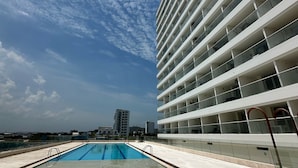 A modern building with a pool and a clear sky. - The Suite Thirteen is a modern, minimalist apartment suite for short-term stays (Cartagena de Indias)