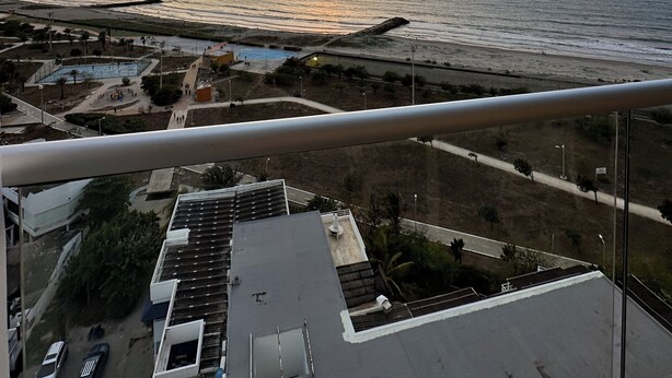 A sunset over a coastal area with a view of the sea, a parking lot, and buildings with flat roofs. - The Suite Thirteen is a modern, minimalist apartment suite for short-term stays (Cartagena de Indias)