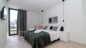 Una camera da letto moderna con un letto, comodini, una sedia e una televisione.
