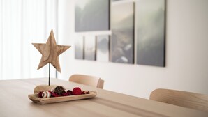Una decorazione a stella di legno su un tavolo con un piatto di cibo e una sedia.