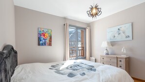 A bedroom with a large bed, a window with curtains, a chandelier, a painting, and a dresser. - Le Panorama du Puy - Dans la station d'Auron (Saint-Étienne-de-Tinée)