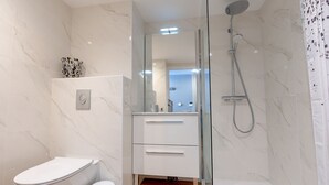 A modern bathroom with a toilet, a shower, and a vanity with drawers. - Le Panorama du Puy - Dans la station d'Auron (Saint-Étienne-de-Tinée)