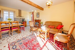A cozy living room with a sofa, chairs, a coffee table, and a fireplace. - A l'escale - Maison pour 5 avec Jardin (Plesder)