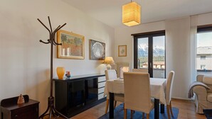Un comedor con una mesa, sillas, una lámpara y un perchero.