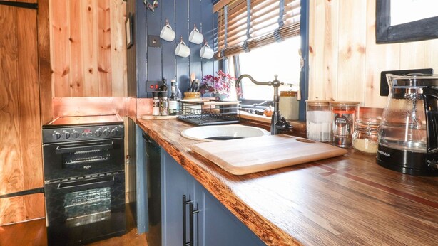 A kitchen with a built-in oven, a sink, and a coffee maker. - Dunfell Shepherd's Hut (Appleby-in-Westmorland)