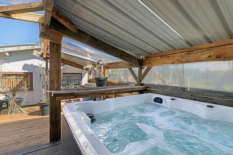 Outdoor spa tub. Chalet "De Ferme - Spa - Gironde" with Private Terrace, Wi-Fi, and Air Conditioning