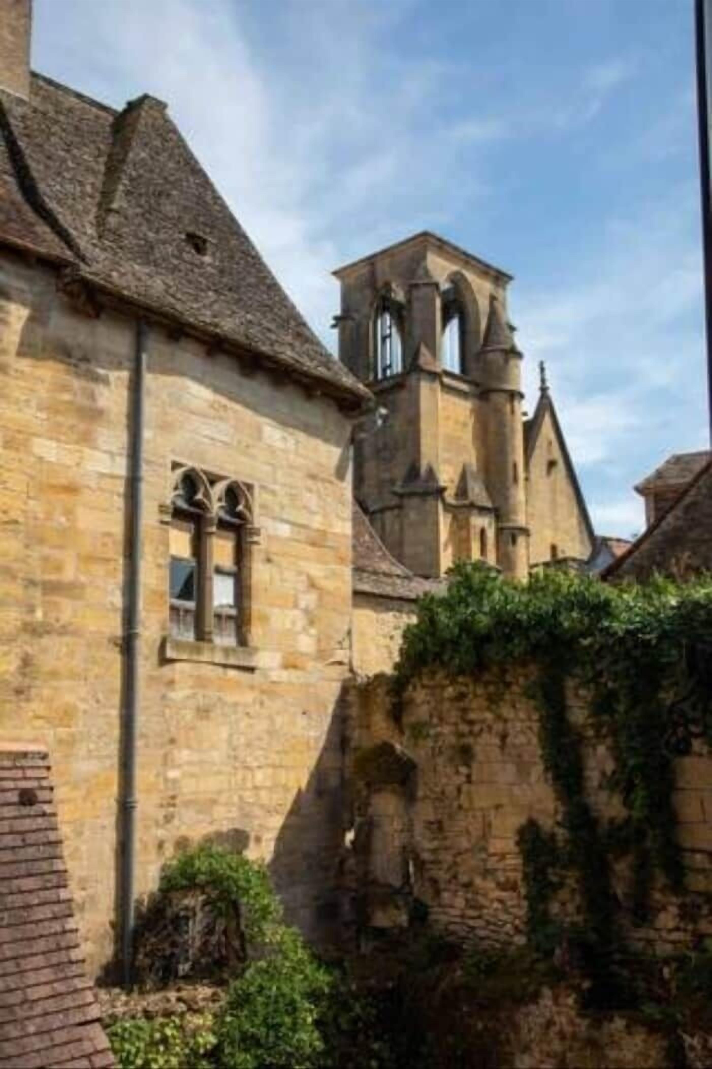 Un edificio in pietra con finestre ad arco e un campanile.