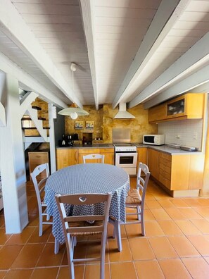 Uma cozinha com armários de madeira, fogão e micro-ondas.