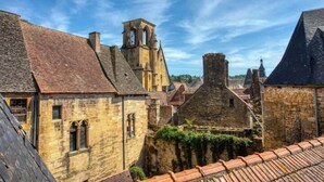 A historic stone building with a steeply pitched roof, a bell tower, and a small window. - "Betty B's apartments Historic center (Sarlat-la-Canéda)