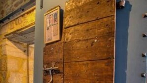 A wooden cabinet with multiple compartments, a stone wall, and a blue metal structure. - "Betty B's apartments Historic center (Sarlat-la-Canéda)