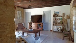 A living room with a television, wooden furniture, and a bookshelf. - Les Tavernes*Authentic*Calm*Pool (Daglan)